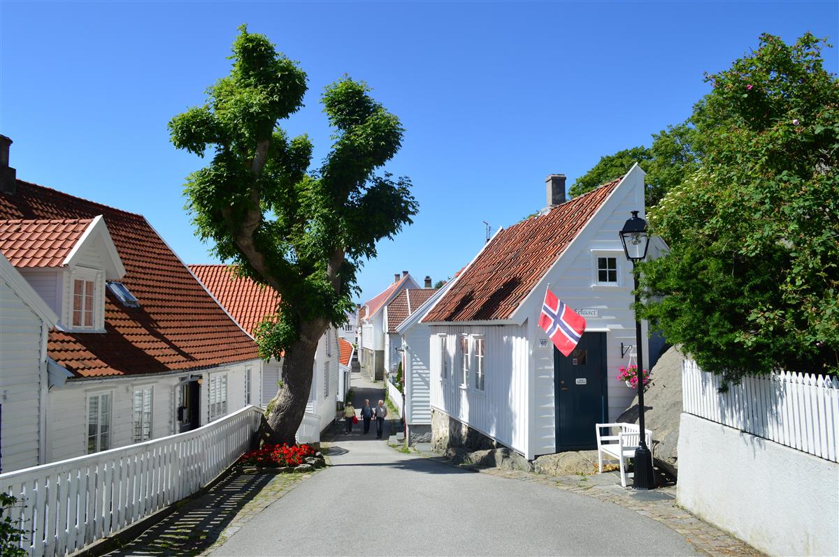 Vaskehuset med norsk flagg nedover Søragadå i Skudeneshavn - Klikk for stort bilde