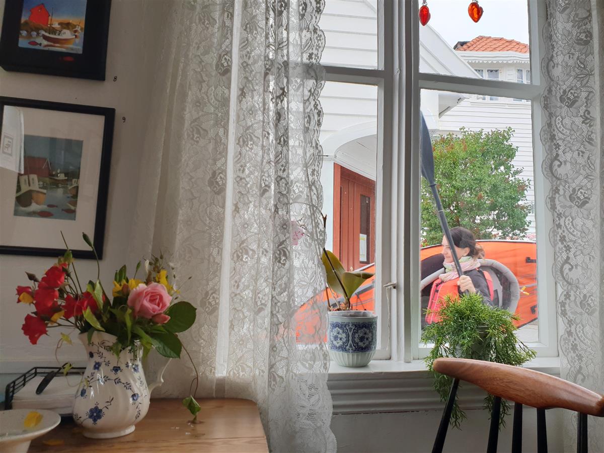 Inne fra verdens minste kafe med utsikt ut vindu med blondegardin - Klikk for stort bilde